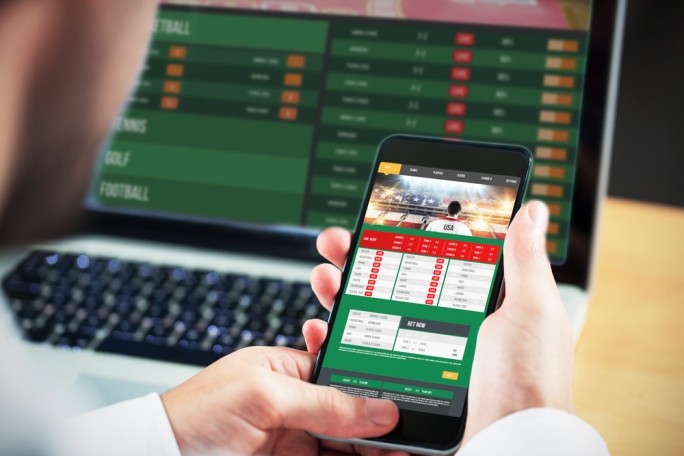 Sports betting on phone and laptop